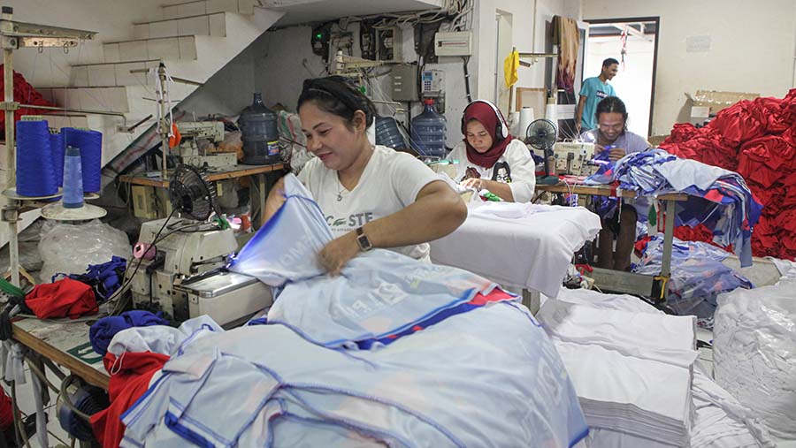 Pekerja menyelesaikan jahitan baju di rumah konveksi kawasan Jagakarsa, Jakarta, Kamis (26/10/2023). (Bloomberg Technoz/Andrean Kristianto)