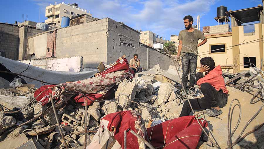Warga Palestina duduk di antara puing bangunan usai serangan rudal Israel di Khan Younis, Gaza selatan, Senin (30/10/2023).  (Ahmad Salem/Bloomberg)