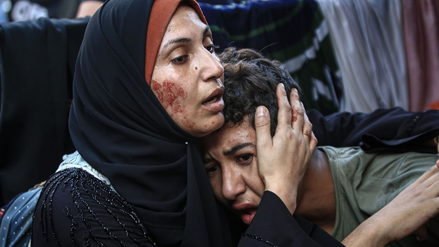 Wanita Palestina menghibur seorang anak usai serangan udara Israel di Jabaliya, Gaza utara, Sabtu (4/11/2023). (Ahmad Salem/Bloomberg)