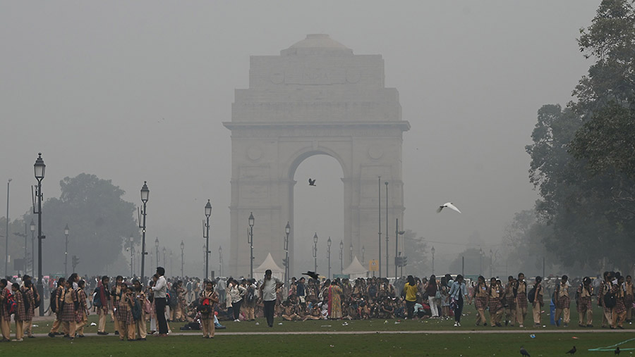 Anak-anak sekolah dan wisatawan mengunjungi Gerbang India saat kabut polusi tebal di New Delhi, India, Sabtu (4/11/2023). (Prakash Singh/Bloomberg)