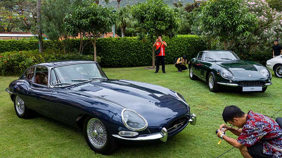 Para pengunjung juga berfoto salah satunya di mobil Jaguar E-Type (kiri) dan Ferrari 275. (Paul Yeung/Bloomberg)
