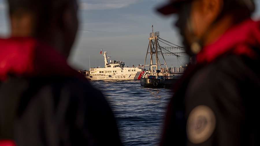 Penjaga Pantai Filipina melihat kapal Tiongkok saat misi ke kapal BRP Sierra Madre di Laut Cina Selatan, Jumat (10/11). (Lisa Marie David/Bloomberg)