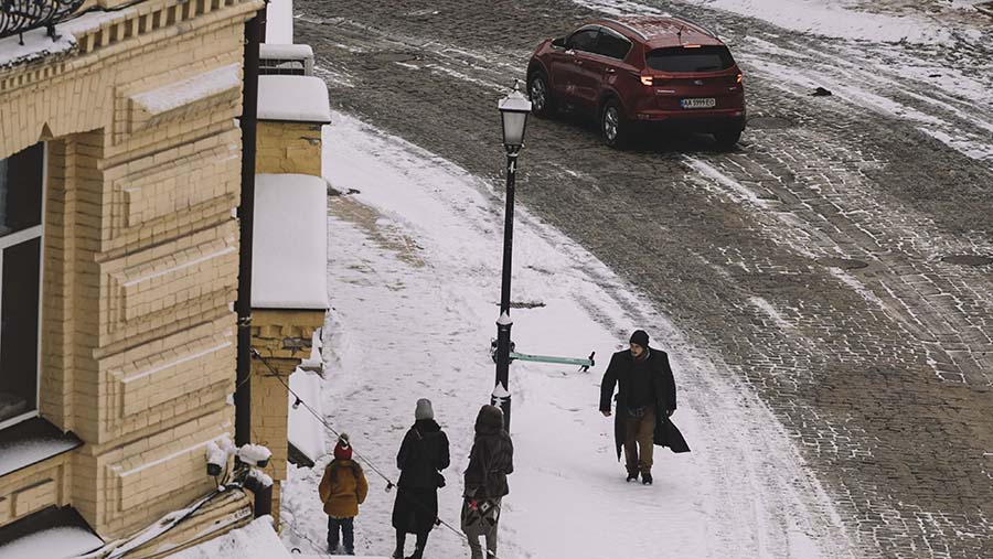 Warga berjalan di sepanjang trotoar yang tertutup salju di Andriyivskyi Uzviz di Kyiv, Ukraina, Rabu (22/11/2023). (Andrew Kravchenko/Bloomberg)