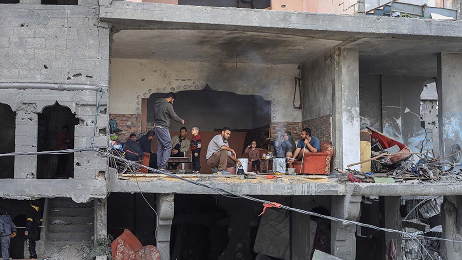 Warga Palestina di rumah mereka yang hancur di kamp pengungsi di Nuseirat, Gaza, Sabtu (25/11/2023). (Ahmad Salem/Bloomberg)