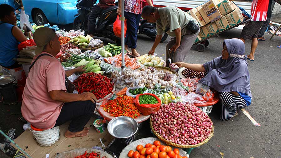 Pedagang melayani pembeli di Pasar Minggu, Jumat (1/12/2023). (Bloomberg Technoz/Andrean Kristianto)