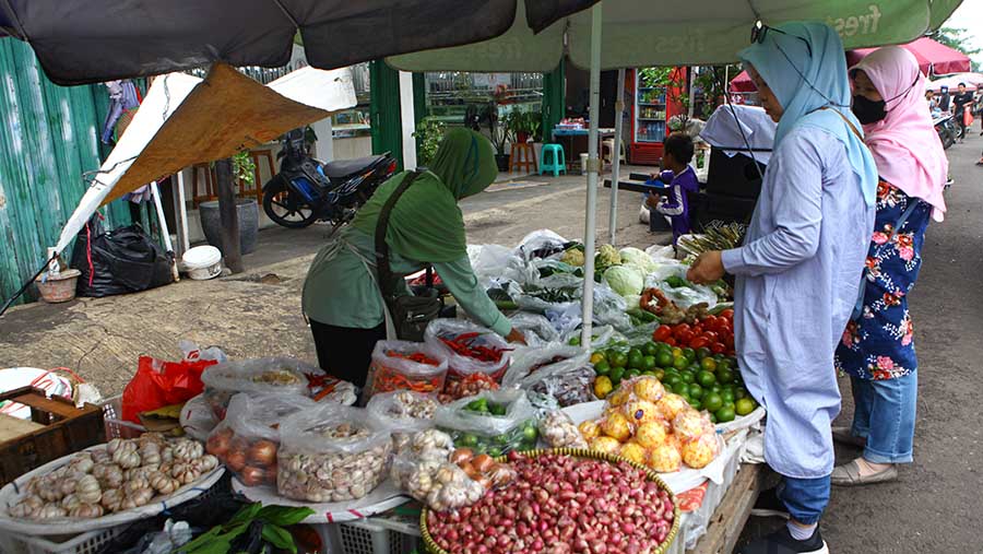 Pedagang melayani pembeli di Pasar Minggu, Jumat (1/12/2023). (Bloomberg Technoz/Andrean Kristianto)