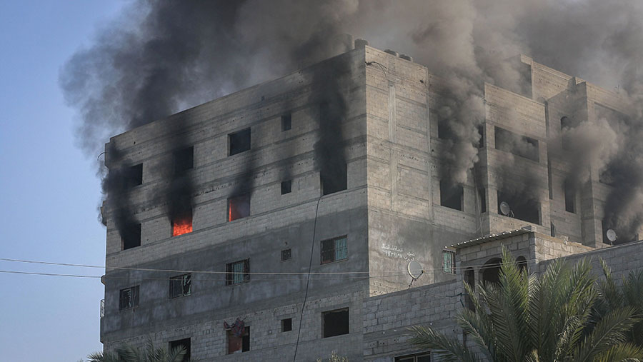 Sebuah bangunan terbakar setelah serangan udara Israel di Khan Younis, Gaza, Sabtu (2/12/2023).(Ahmad Salem/Bloomberg)