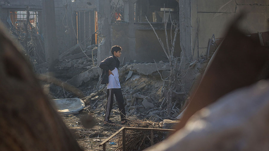Pemuda Palestina melihat sisa puing bangunan yang hancur usai serangan udara Israel di Khan Younis, Gaza, Sabtu (2/12/2023).  (Ahmad Salem/Bloomberg)