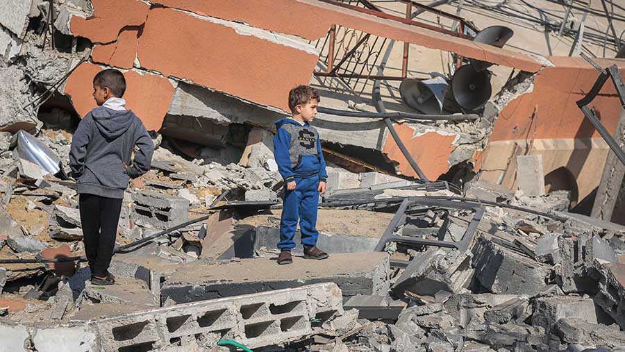 Anak Palestina di reruntuhan bangunan yang hancur akibat serangan udara Israel di Khan Younis, Gaza, Sabtu (2/12/2023).  (Ahmad Salem/Bloomberg)