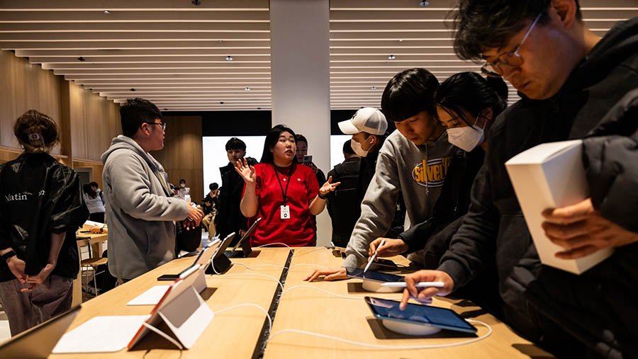 Pelanggan melihat perangkat tablet iPad di toko baru Apple di Hanam, Korsel, Sabtu (9/12/2023). (SeongJoon Cho/Bloomberg)