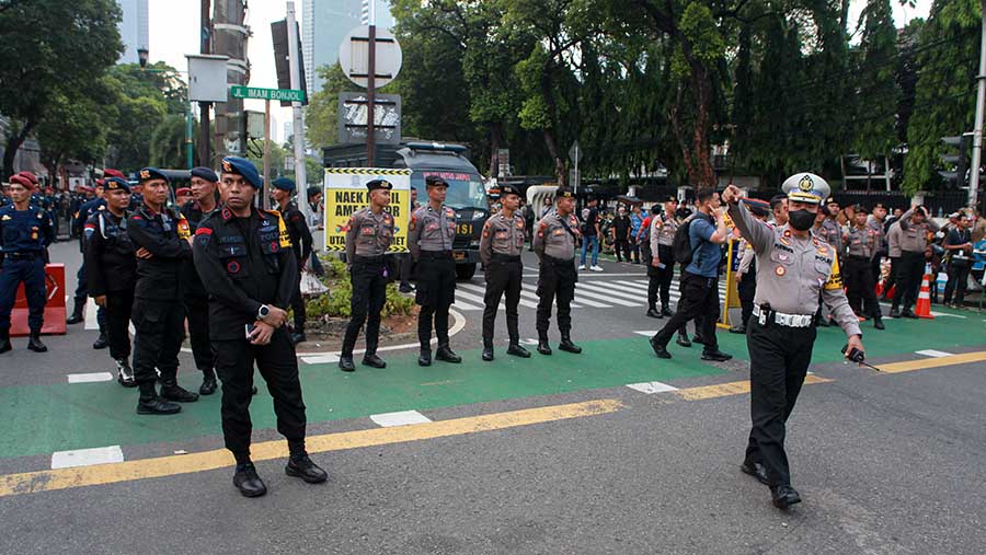 Petugas polisi berjaga di depan Kantor KPU RI jelang Debat Capres, Selasa (12/4/2023). (Bloomberg Technoz/Andrean Kristianto)