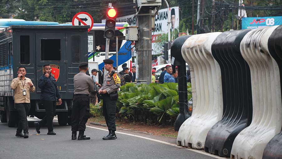 Petugas polisi berjaga di depan Kantor KPU RI jelang Debat Capres, Selasa (12/4/2023). (Bloomberg Technoz/Andrean Kristianto)