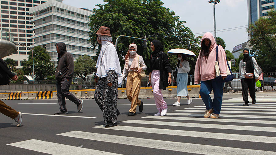 Warga berjalan saat cuaca panas di Jakarta. (Bloomberg Technoz/Andrean Kristianto)