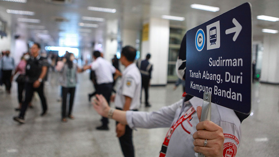 Petugas mengarahkan penumpang KRL Commuter Line  di Stasiun Manggarai, Jakarta, Rabu (20/12/2023). (Bloomberg Technoz/Andrean Kristianto)