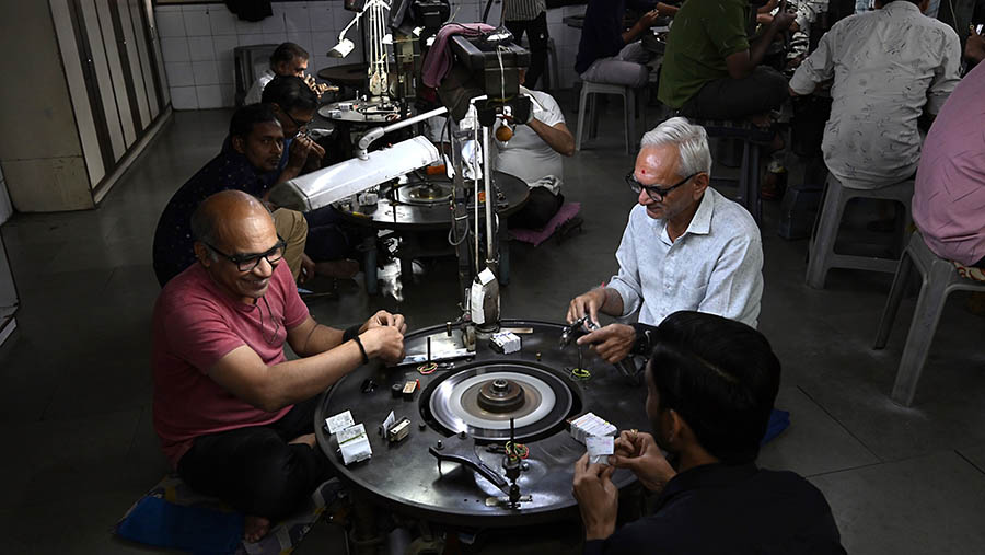 Seorang karyawan memeriksa berlian di sebuah bengkel di Surat, Gujarat, India, Kamis (21/12/2023). (Prakash Singh/Bloomberg)