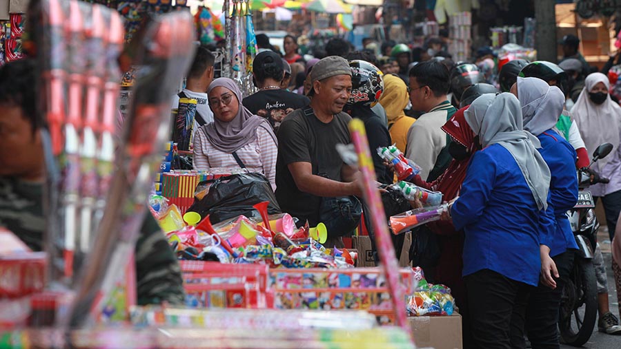 Pedagang melayani pembeli kembang api di Pasar Asemka, Jakarta Barat, Kamis (28/12/2023). (Bloomberg Technoz/Andrean Kristianto)