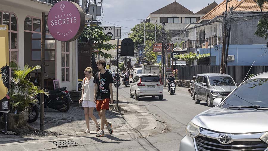 Wisatawan berjalan di jalan Berawa, Bali, Kamis (28/12/2023). (Nyimas Laula/Bloomberg)