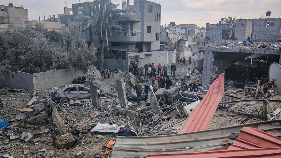 Warga Palestina memeriksa sisa rumah mereka yang hancur akibat serangan Israel di Maghazi, Gaza tengah, Senin (25/12/2023). (Ahmad Salem/Bloomberg)