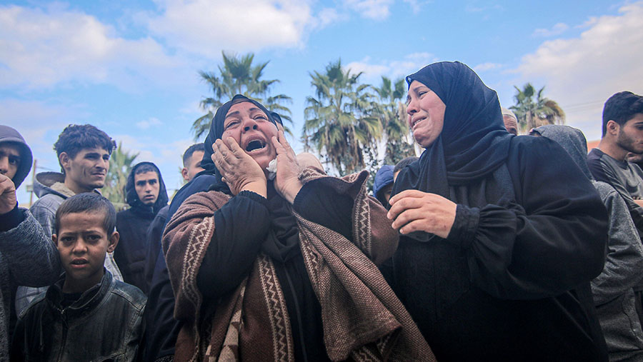 Warga Palestina menangisi korban tewas serangan Israel di kamp Maghazi di RS Martir Al-Aqsa, Gaza tengah, Senin (25/12/2023). (Ahmad Salem/Bloomberg)