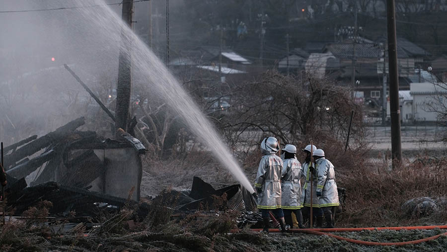 Petugas pemadam kebakaran memadamkan api usai gempa bumi di Nanao, Prefektur Ishikawa, Jepang, Selasa (2/1/2024). (Soichiro Koriyama/Bloomberg)