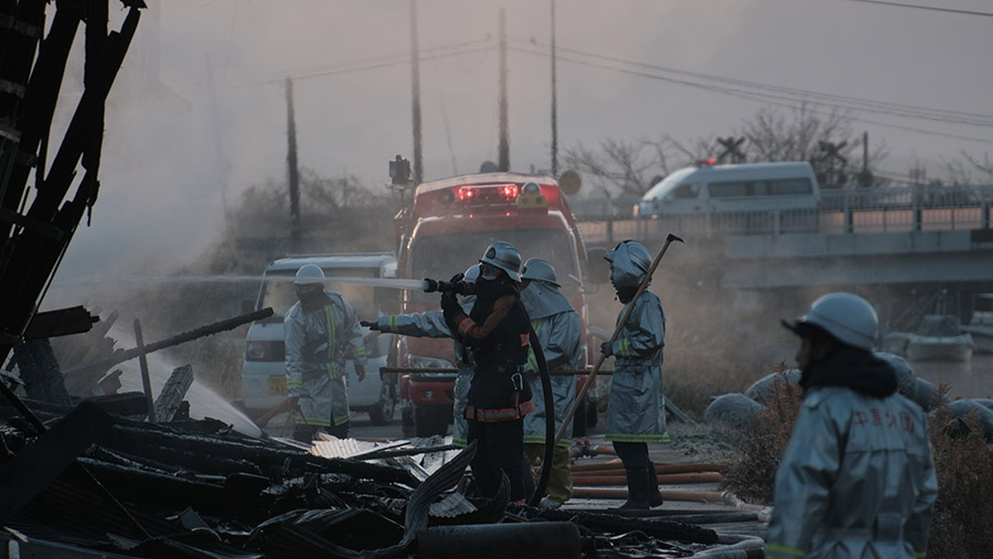 Petugas pemadam kebakaran memadamkan api usai gempa bumi di Nanao, Prefektur Ishikawa, Jepang, Selasa (2/1/2024). (Soichiro Koriyama/Bloomberg)
