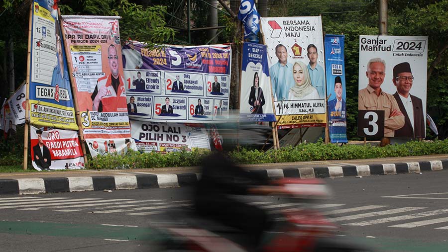 Kendaraan melintas di dekat alat peraga kampanye di Jakarta, Kamis (4/1/2024). (Bloomberg Technoz/Andrean Kristianto)