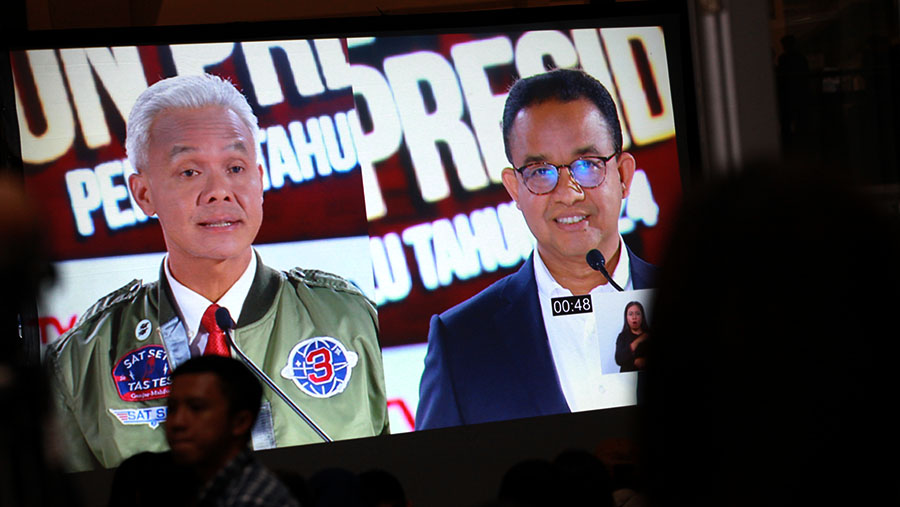 Layar menmapilkan capres Ganjar Pranowo & Anies Baswedan saat debat ketiga di Istora Senayan, Minggu (7/1/2024). (Bloomberg Technoz/Andrean Kristianto