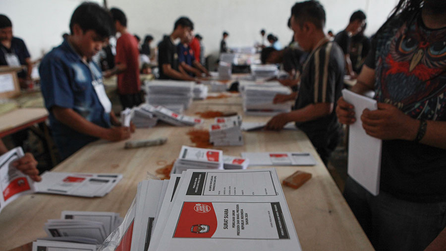 Pekerja melipat surat suara pemiihan presiden (Pilpres) 2024 di gudang KPU Jakarta Timur, Selasa (9/1/2024). (Bloomberg Technoz/Andrean Kristianto)