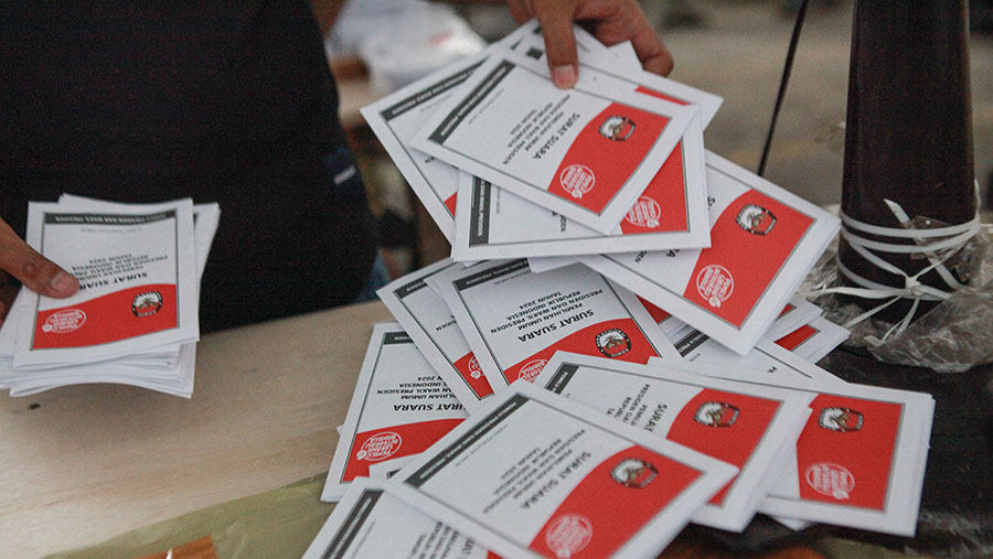 Pekerja melipat surat suara pemiihan presiden (pilpres) 2024 di gudang KPU Jakarta Timur, Selasa (9/1/2024). (Bloomberg Technoz/Andrean Kristianto)