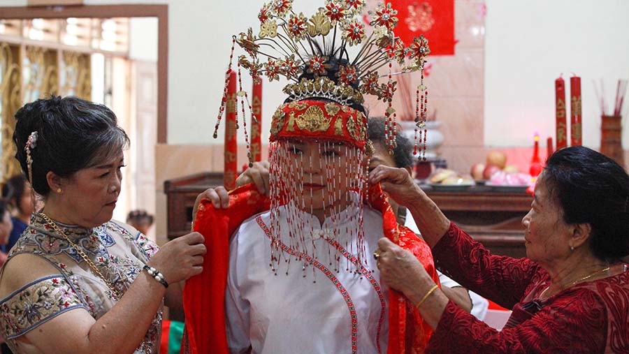 Pengantin wanita bersiap untuk melakukan prosesi upacara Cio Tao. (Bloomberg Technoz/Andrean Kristianto)