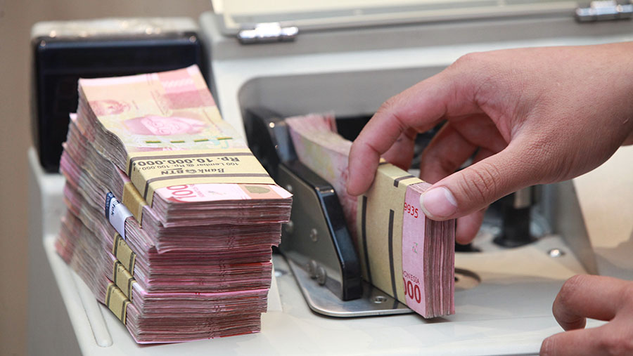 Karyawan menghitung uang rupiah di salah satu bank di Jakarta, Selasa (16/1/2024). (Bloomberg Technoz/Andrean Kristianto)
