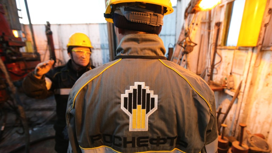 Seorang pekerja mengenakan jaket keselamatan bermerek saat bekerja di anjungan pengeboran yang dioperasikan oleh Rosneft PJSC/Bloomberg-Andrey Rudakov