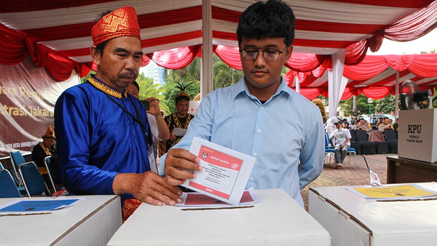 Peserta memasukkan surat suara ke kotak saat simulasi pemungutan suara pemilu 2024 di Jakarta, Rabu (17/1/2024) (Bloomberg Technoz/Andrean Kristianto)