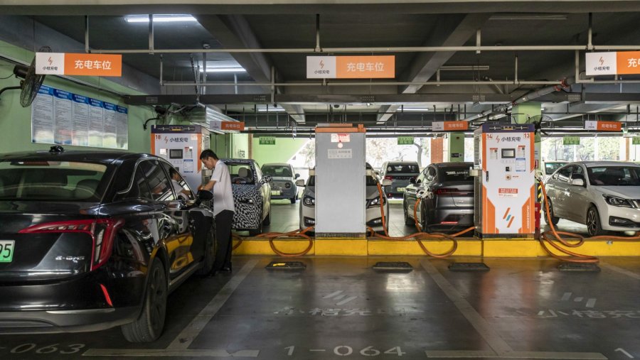 Pengguna mobil listrik melakukan pengisian daya baterai./Bloomberg