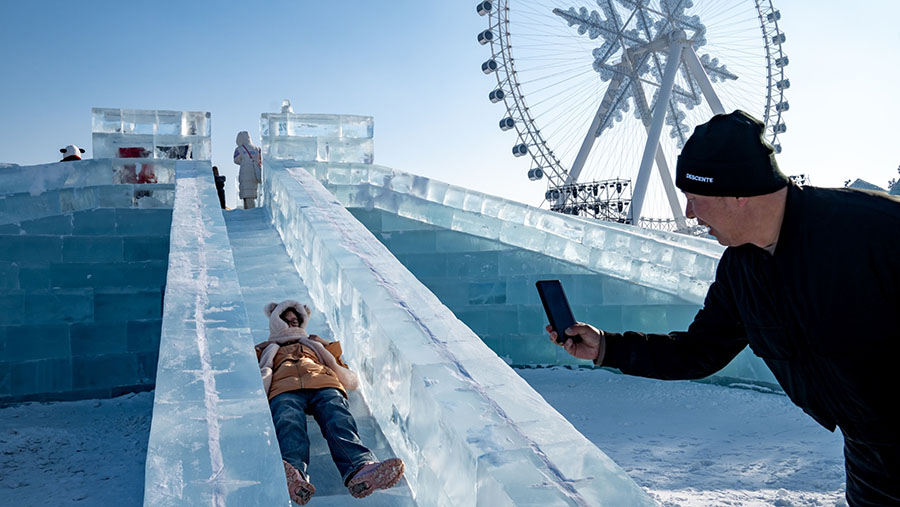 Tak hanya bangunan, festival es Harbin juga terdapat seluncuran es yang memikat pengunjung. (Andrea Verdelli/Bloomberg)