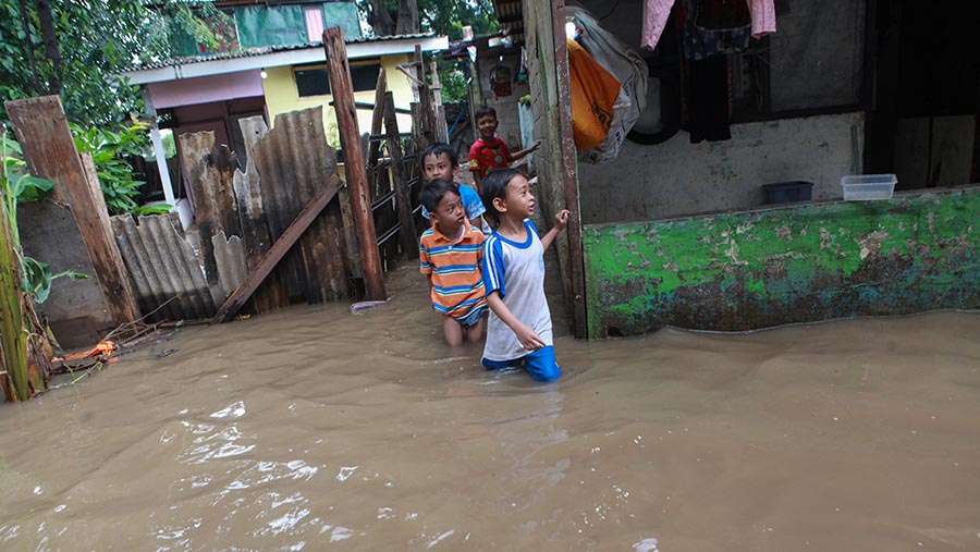 Sejumlah anak-anak memanfaatkan banjir tersebut untuk bermain air. (Bloomberg Technoz/Andrean Kristianto)