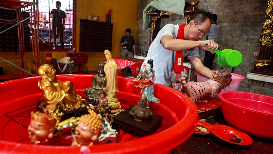 Dalam prosesi yang penuh makna ini, patung-patung Buddha menjalani serangkaian tahapan pencucian. (Bloomberg Technoz/Andrean Kristianto)