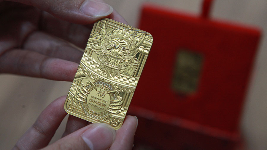 Karyawan menunjukkan emas imitasi di salah satu butik emas Antam di Jakarta, Jumat (2/2/2022). (Bloomberg Technoz/Andrean Kristianto)
