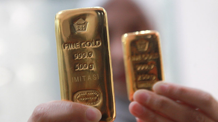 Karyawan menunjukkan emas imitasi di salah satu butik emas Antam di Jakarta, Jumat (2/2/2022). (Bloomberg Technoz/Andrean Kristianto)
