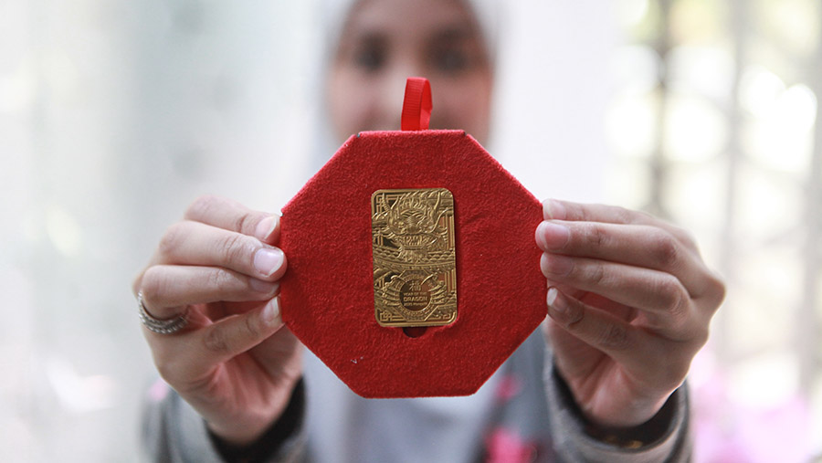 Karyawan menunjukkan emas imitasi di salah satu butik emas Antam di Jakarta, Jumat (2/2/2022). (Bloomberg Technoz/Andrean Kristianto)

