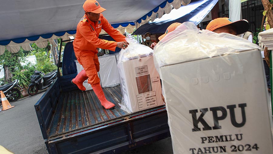 Petugas mengangkat logistik pemilu ke mobil di GOR Cempaka Putih, Jakarta, Selasa (13/2/2023). (Bloomberg Technoz/Andrean Kristianto)