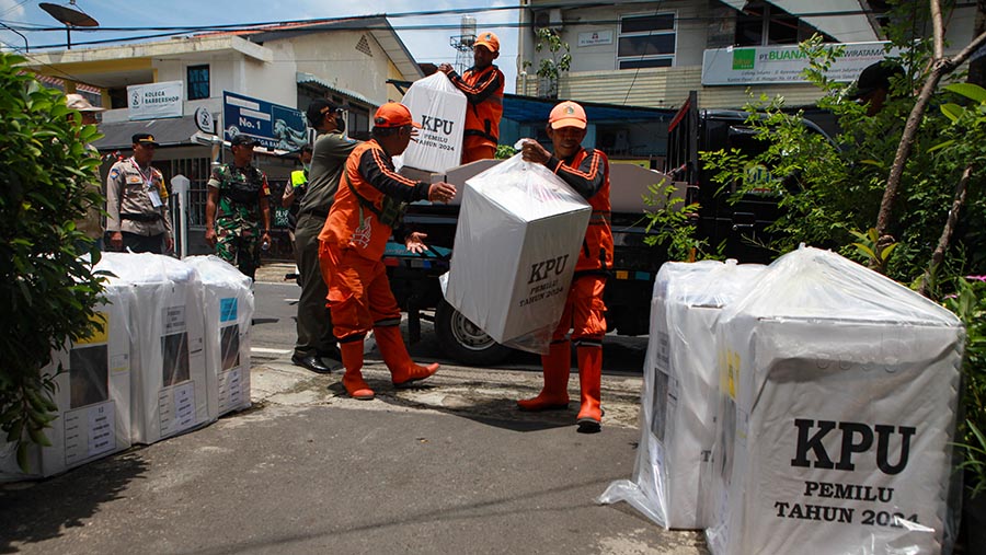 Petugas mengangkat logistik pemilu dengan gerobak di kawasan Rawasari, Jakarta, Selasa (13/2/2023). (Bloomberg Technoz/Andrean Kristianto)