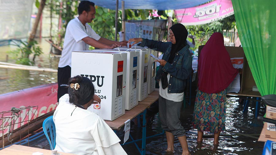 Lokasi pemungutan suara yang digenangi air di kawasan Sukapura, Pegangsaan Dua, Jakarta, Rabu (14/2/2024). (Bloomberg Technoz/Andrean Kristianto)