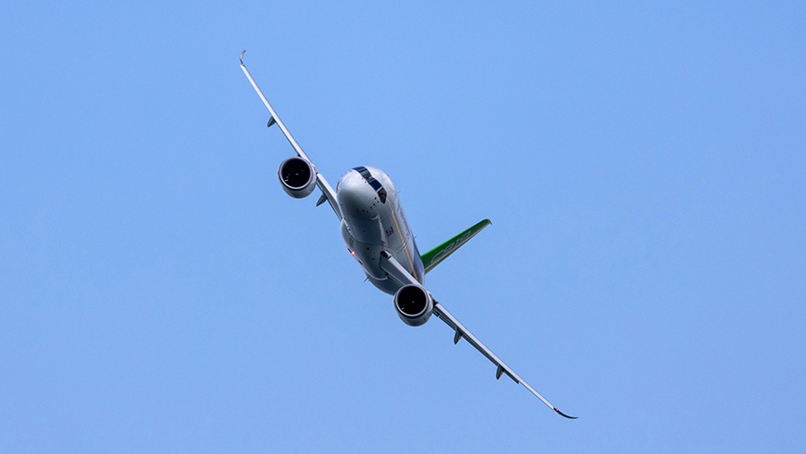 Pesawat Comac C919 China melakukan pertunjukan terbang di Singapore Airshow, Singapura, Selasa (20/2/2024). (SeongJoon Cho/Bloomberg)