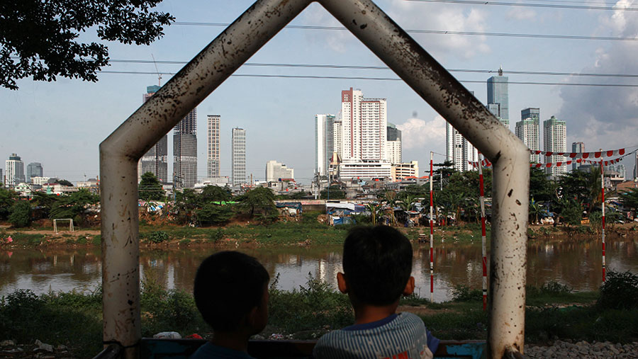 Anak kecil melihat gedung bertingkat di Jakarta, Kamis (22/2/2024). (Bloomberg Technoz/Andrean Kristianto)