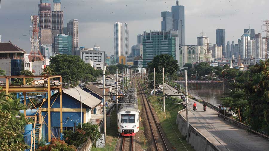 Kereta bandara dengan latar gedung bertingkat melintas di kawasan Tomang, Jakarta, Kamis (22/2/2024). (Bloomberg Technoz/Andrean Kristianto)