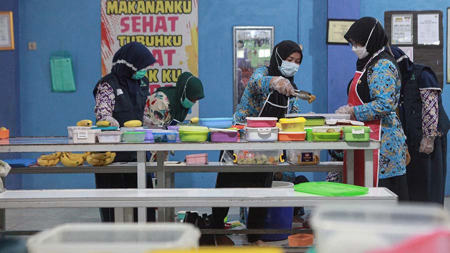 Petugas menyiapkan makanan untuk simulasi program makan siang di SMPN 2 Curug, Kamis (29/2/2024). (Bloomberg Technoz/Andrean Kristianto) 