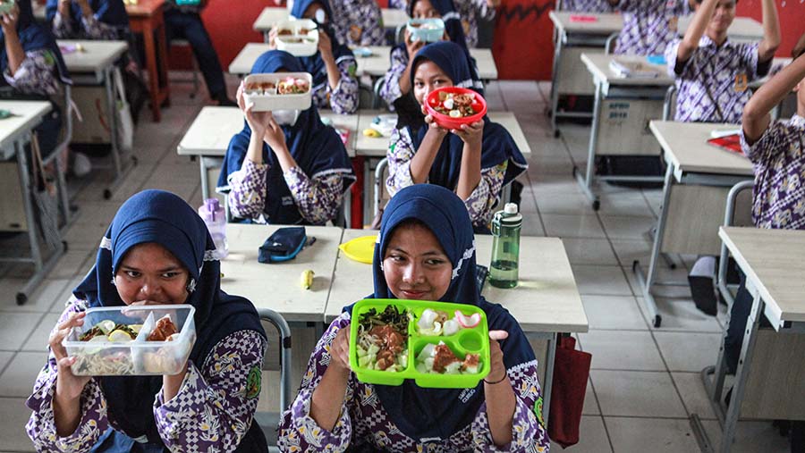 Siswa makan siang bersama saat simulasi program makan siang di SMPN 2 Curug, Kab. Tangerang, Kamis (29/2/2024). (Bloomberg Technoz/Andrean Kristianto)