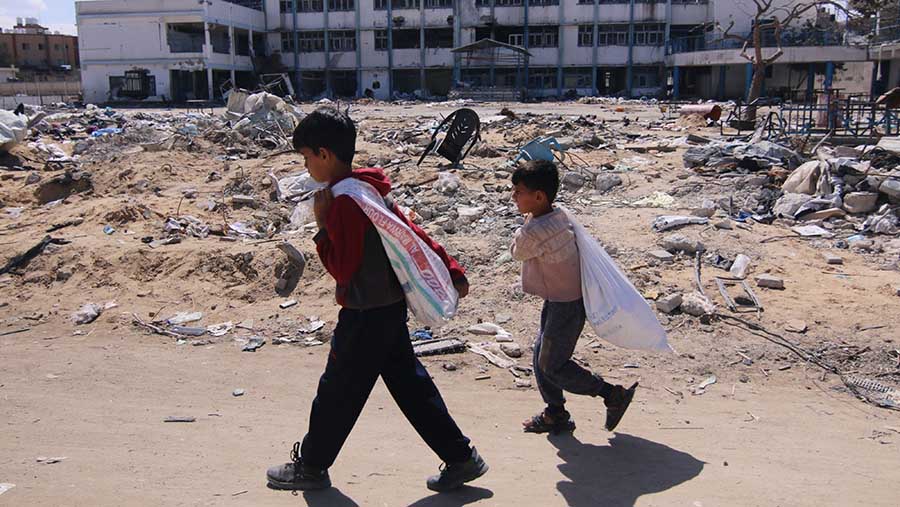 Anak-anak Palestina berjalan diantara puing bangunan pasca serangan Israel di Khan Younis, Gaza selatan (8/3/2024). (Ahmad Salem/Bloomberg)