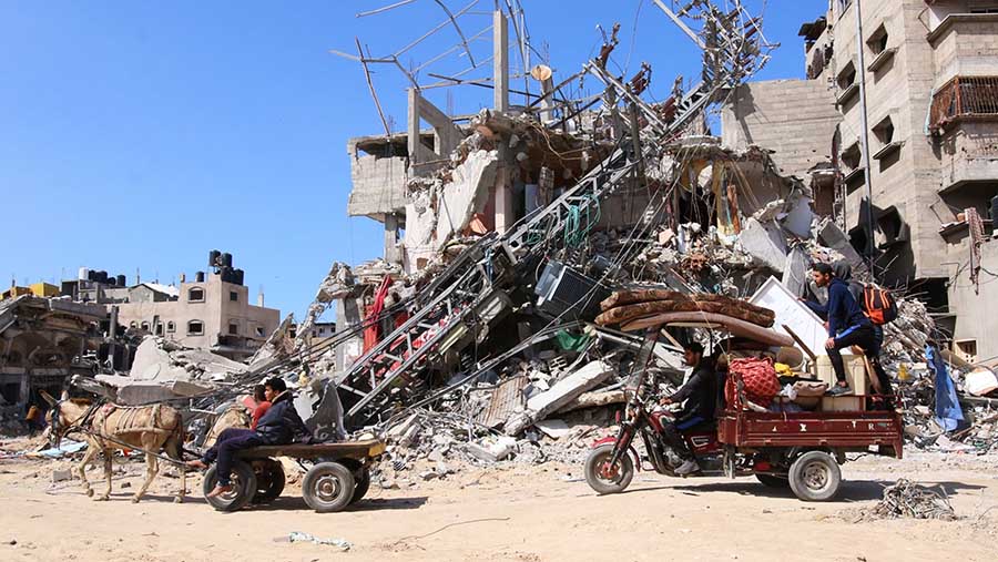 Warga Palestina mengangkut harta benda mereka setelah serangan Israel di Khan Younis, Gaza selatan (8/3/2024). (Ahmad Salem/Bloomberg)